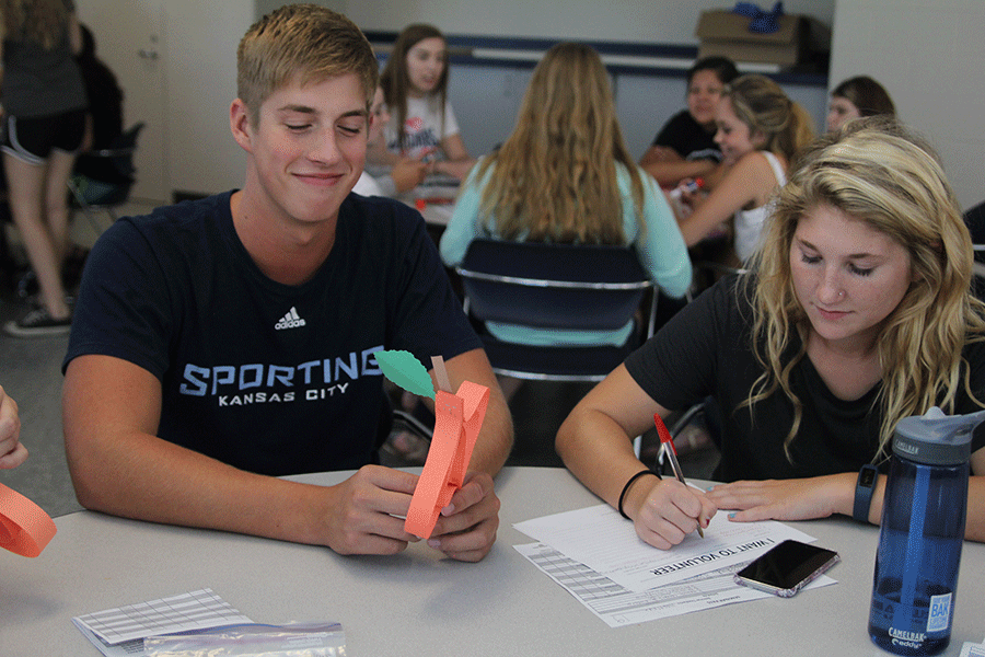 After working on their crafts, juniors Garrison Fangman and Megan Breninger sign up to volunteer for a food drive.