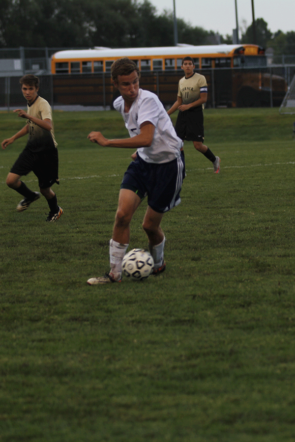 Freshman Jake Ashford dribbles the ball down the field.