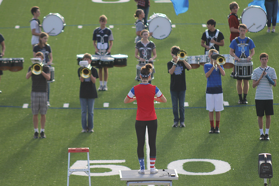 In preparation for the halftime show, the band takes direction from senior Lindsay Hamner the morning of the football game against Blue Valley Northwest on Friday, Sept. 11. The band, as well as the football team, dance team and physical education classes have been able to use the turf since it was placed on the field.