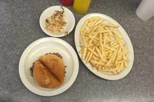 Single cheeseburger, fries and a side of grilled onions from Town Topic Hamburgers in Kansas City, Missouri.