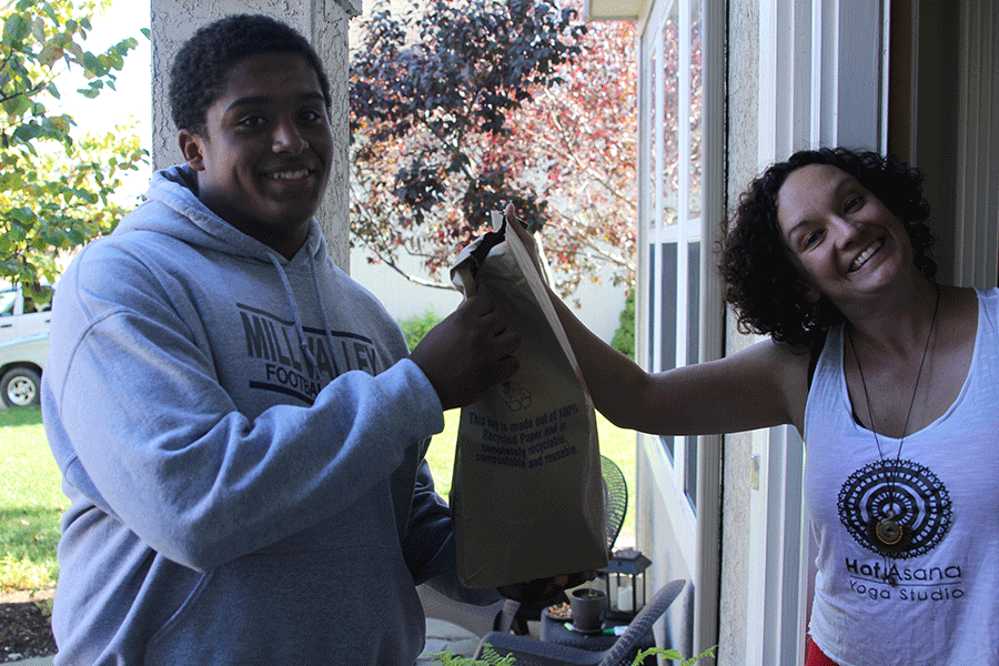 Junior Alec Derritt smiles for the camera as he receives a bag filled with canned goods for NHSs Trick or Treat so others can eat on Sunday, Oct. 25.  