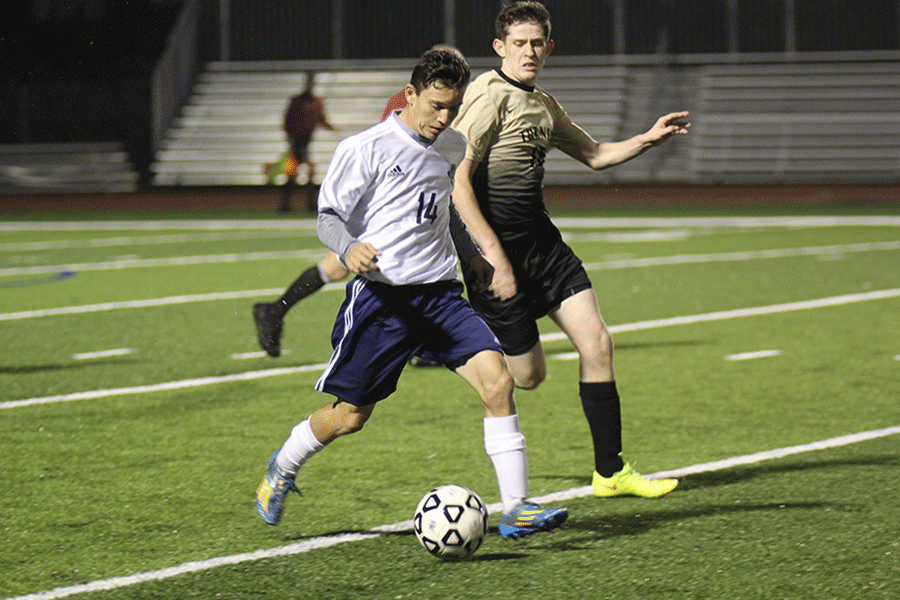 Dribbling the ball around his opponent at the regional soccer game on Tuesday, Oct. 27, sophomore Daniel Nicot focuses on the ball. The team won 3-1 against Turner and will advance in regionals.