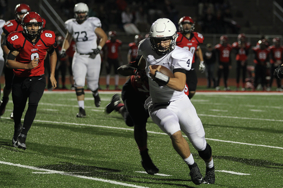 While running the ball, senior Logan Koch avoids being tackled at the away football game against Lansing High School on Friday, Oct. 9.