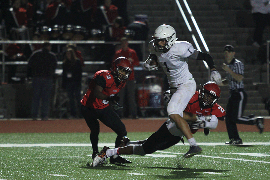 Senior Christian Jegen is tackled in midair as he runs the ball.