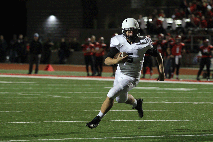 Sophomore quarterback Brody Flaming runs the ball during a play at the away football game against Lansing High School on Friday, Oct. 9.