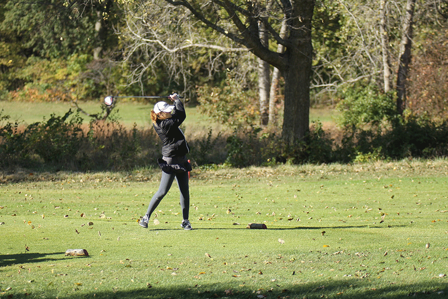 Teeing off, junior Grace Van Inwegen watches her ball as it lands.