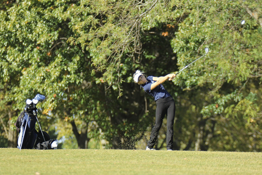 Keeping her eyes on the ball, junior Claire Anderson hits the ball closer to the putting green.
