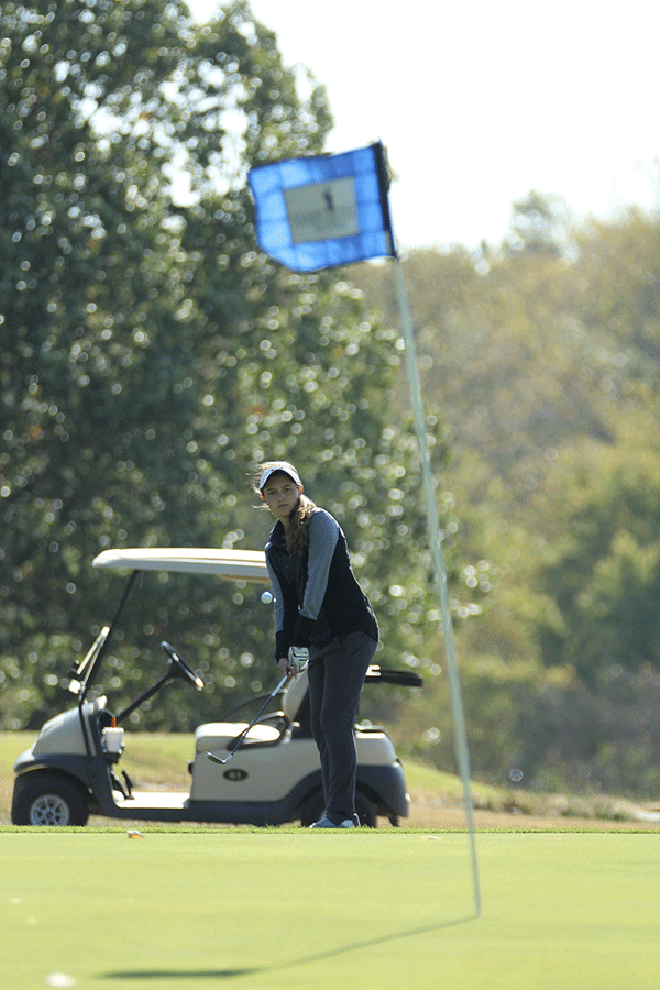 Freshman Sarah Lawson chips her ball closer to the hole.