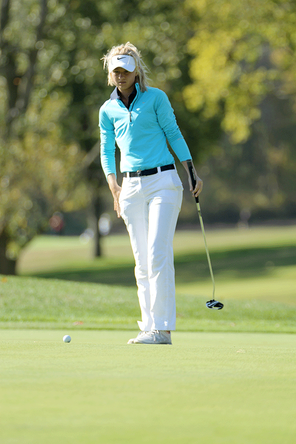 Junior Courtney Carlson determines how she will putt the ball.