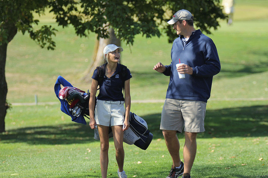 Talking enthusiastically, sophomore Bella Hadden, shares with Coach Walters her score and how she has been playing.