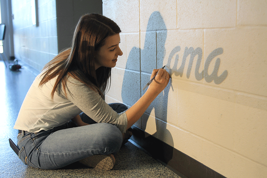 As a part of the NAHS project, senior Morgan Schuler traces the outlines for the lower C-wing mural on Thursday, Oct. 1.