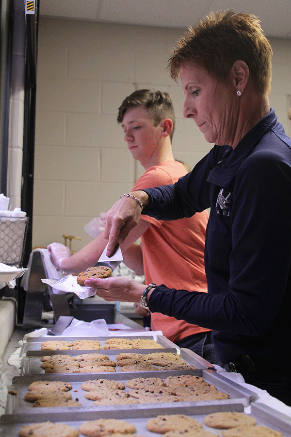 Catty Shack sponsor Dianna Heffernon slides a cookie into a bag to sell to students on Friday, Oct. 23. 