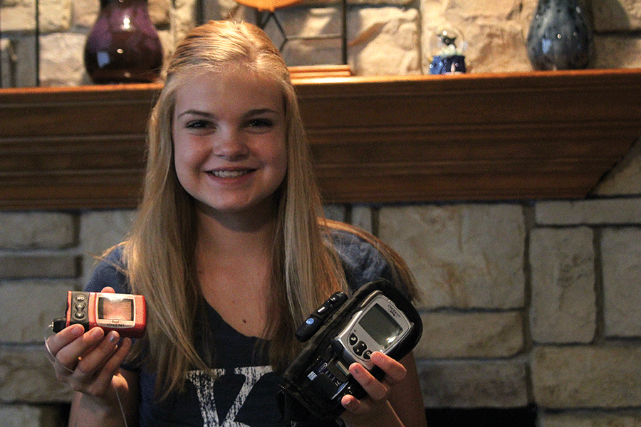 Freshman Kaylee West holds her insulin pump and glucose monitor.  A lot of kids it takes a long time [to get the pump], but I got it only like two months afterwards. I got it really fast so I didn’t have to do a lot of injections, West said.