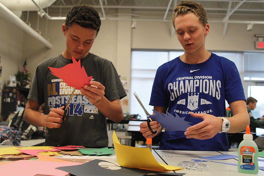 To help art teacher Jodi Ellis, senior Dan Thomas and sophomore James Tharp cut out monsters to decorate Elliss door during red ribbon week on Tuesday, Oct. 27.