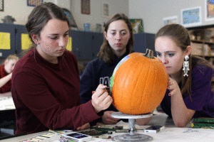 Working in a group, freshman Keme Platt uses oil pastels on her pumpkin.