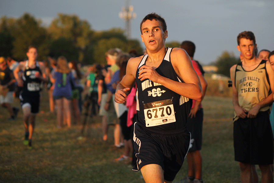 With his eyes on the finish line, sophomore Justin Grega pumps his arm and sprints to the end of the race at Shawnee Mission Park on Thursday, Oct. 8. Both the boys and girls team finished first in the Cat Classic.
