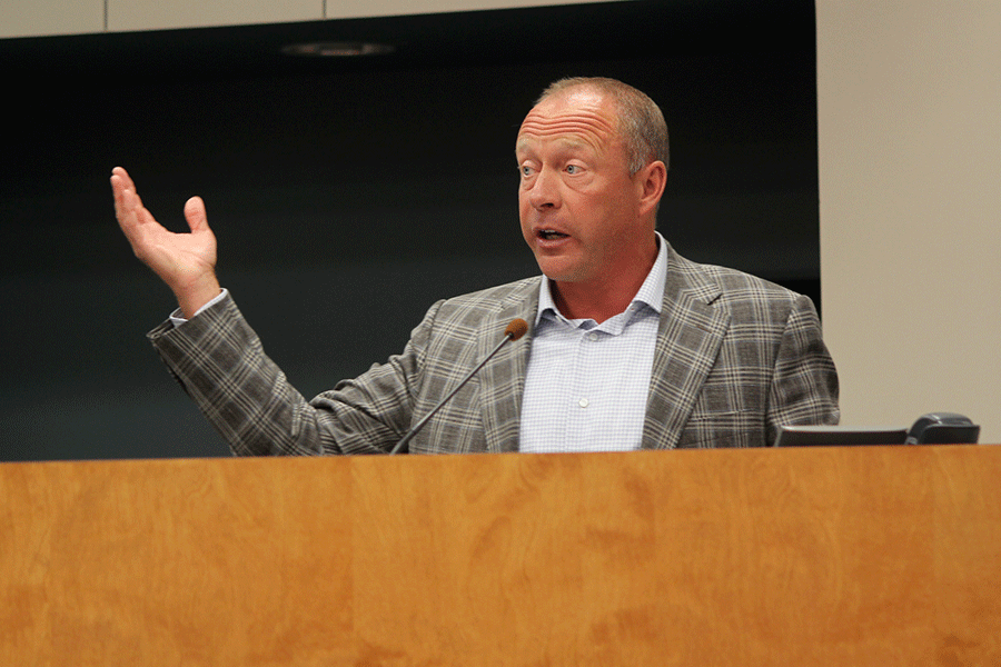 Raising one hand, Board candidate Don Clark explains how, if elected to the Board, he would measure their success. 