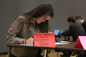 While in the prep room at the Blue Valley West DECA competition on Wednesday, Nov. 4., junior Meghan Burke gets ready for her upcoming series.