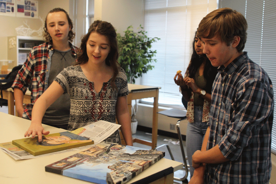 Senior Morgan Schuler shows her art to sophomore Tyler Orbin  during the NAHS art show on Thursday, Nov. 6.