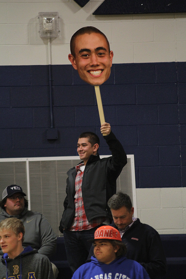 2014 graduate Henry Midyett raises senior Chase Midyetts FatHead. 