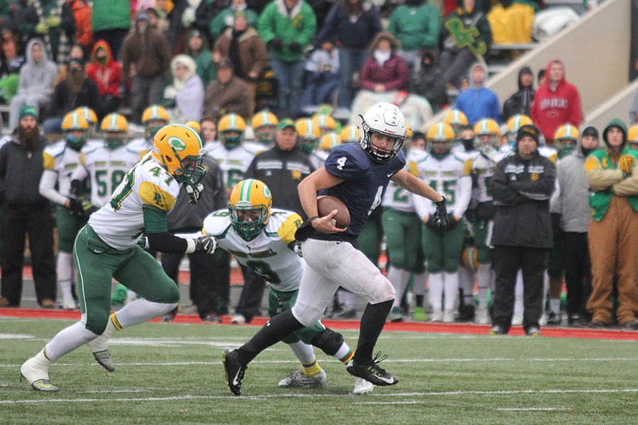 Senior quarterback Logan Koch avoids the tackle while running the ball down field.