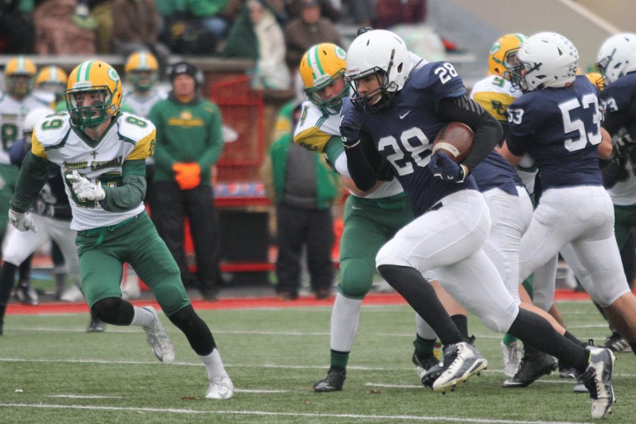 Sophomore running back Ike Valencia runs past Bishop Carroll defensive linemen.