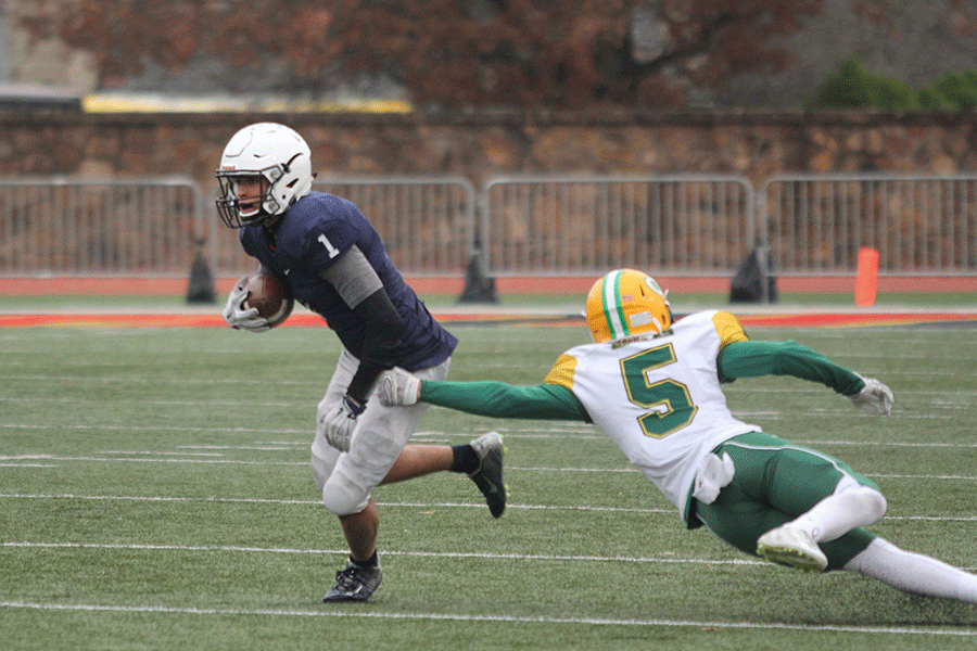 Senior wide receiver Christian Jegen avoids a tackle by Bishop Carroll defensive lineman.