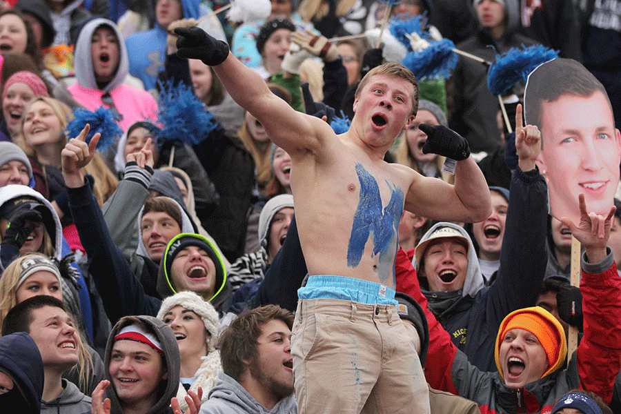 Senior Ryan Anderson points to the scoreboard during a chant by the student section.