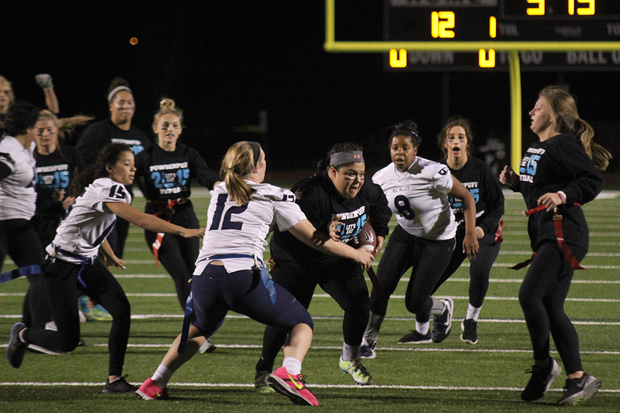 Junior Vanessa Pennington breaks through the senior teams defensive line during the annual Powder Puff football game on Tuesday, Nov. 10. Senior girls defeated the junior girls 24-18. 
