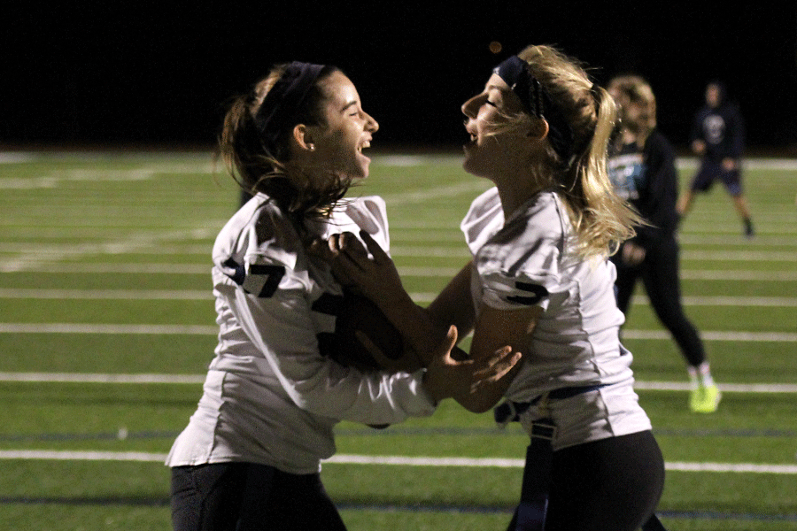 Seniors Kennedy Hoffman and Rebecca Mayberry celebrate after the senior team scores at the Powder Puff game.