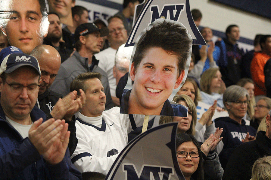 Senior Jack Nielsons father holds up a FatHead of his son during the pep rally.