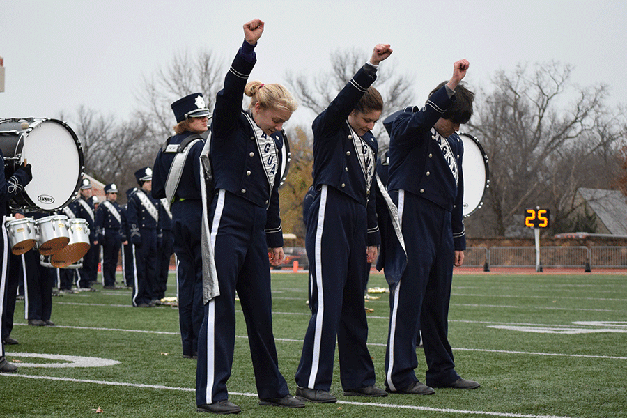 Drum majors Kasey Meeks, Lindsey Hamner and Izik Gousseinov raise their fists in the air during the halftime show Planet Queen.