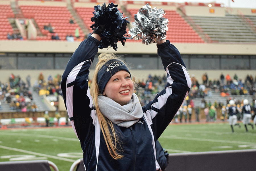 Senior Natalie Golden cheers toward the band section during the game. 