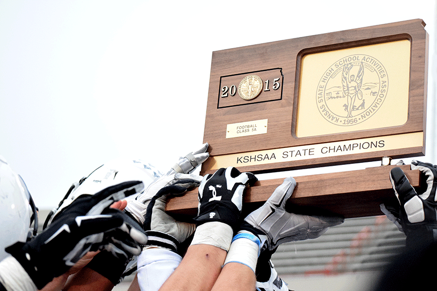 The football team hold up the state championship trophy after the game. 