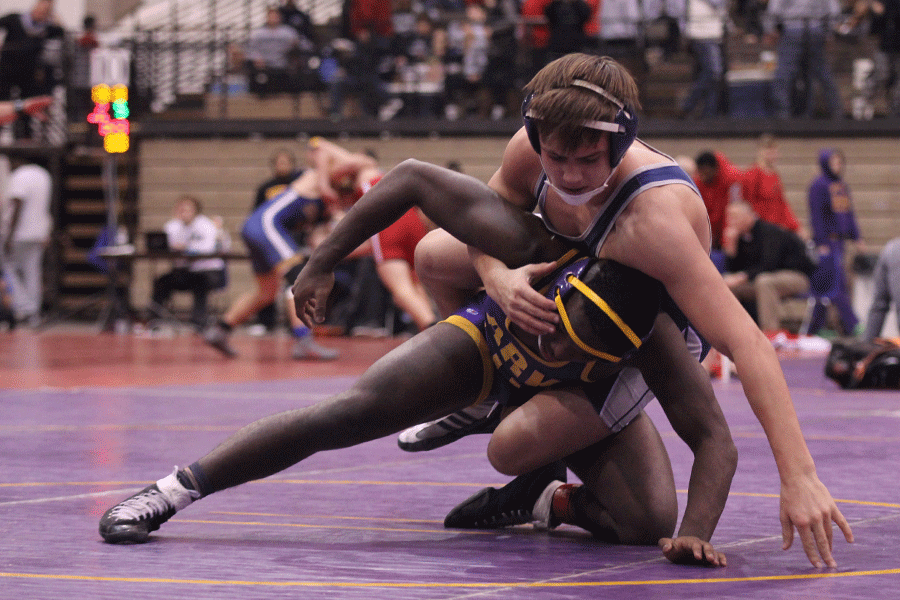 While competing in the second day of the KC Stampede tournament, junior Austin Crocker wrestles his opponent.