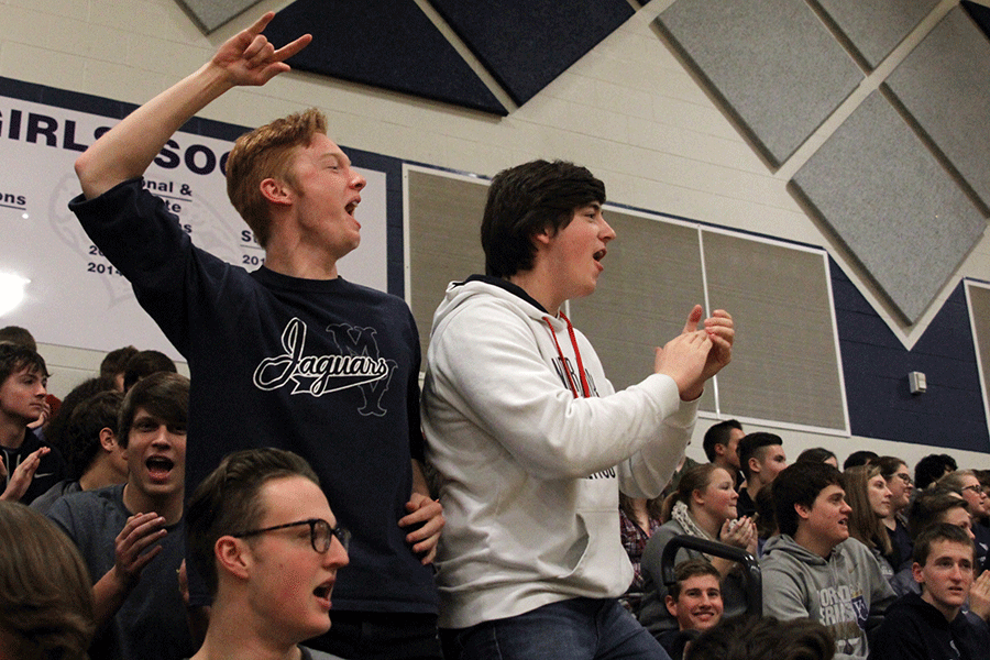Juniors Austin Geise and Kevin McGraw cheer for head football coach Joel Applebee at the end of his speech at the assembly.