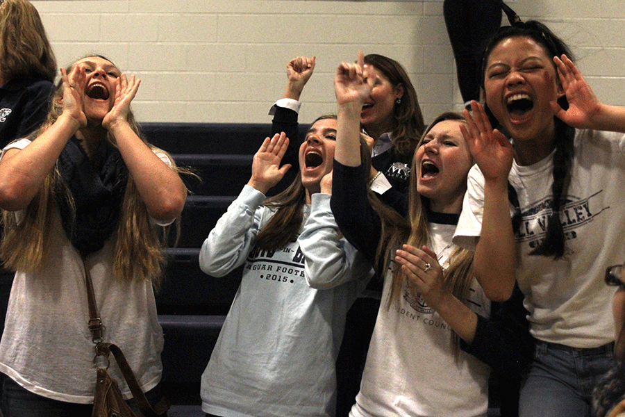 Senior girls sing along to the fight song played by the band at the end of assembly.