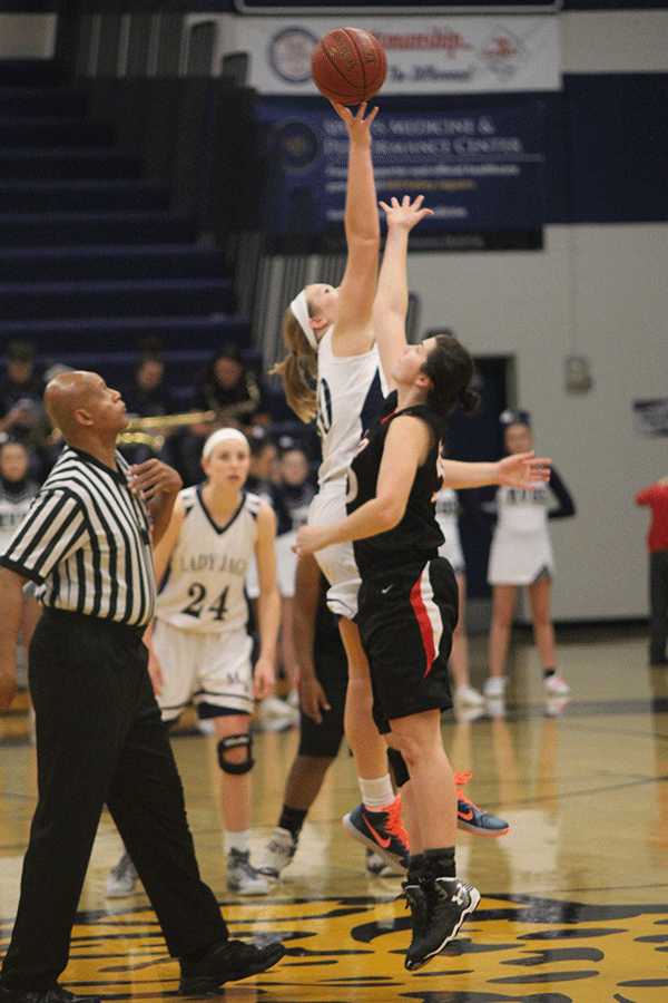 Jumping up for the tipoff, senior Catie Kaifes pushes the ball onto the Jags side of the court.