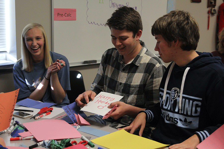After completing a Christmas card, junior Austin Snyder shows his creation to juniors Joey Pentola and Erkia Marsh.