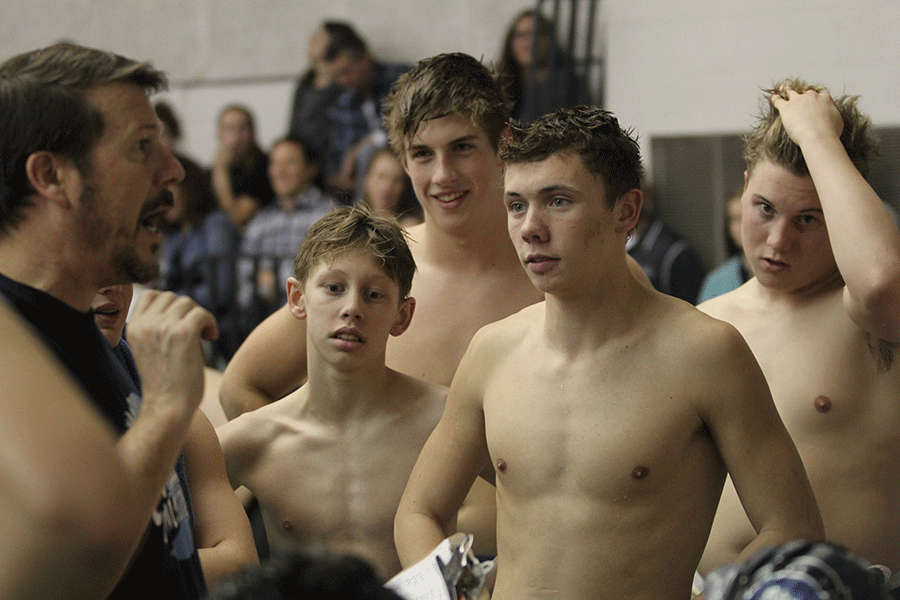 Along with the other swimmers, senior Jeremiah Kemper listens to coach Dervin during a break. 