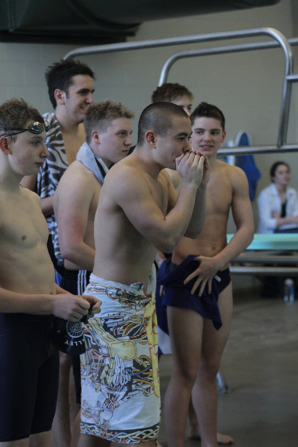 Senior Chase Midyett leads some of his team in cheering on a fellow swimmer.
