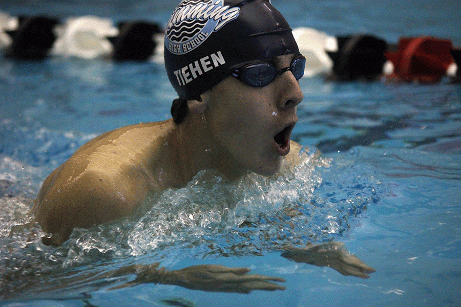 Coming up for air, junior Jacob Tiehen competes in the 100 yard breaststroke.