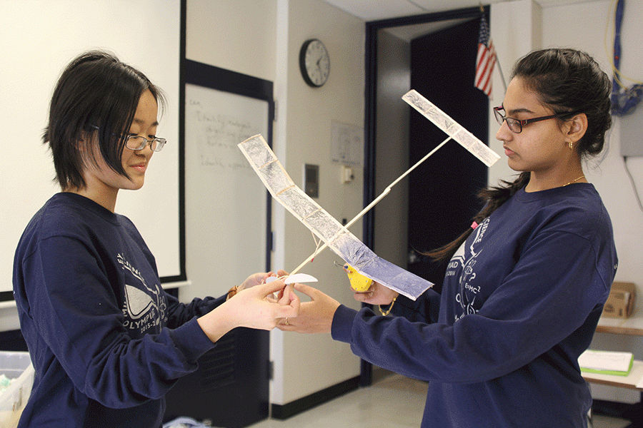 To fly their plane for the event Wright Stuff, seniors Nadia Suhail and T-Ying Lin spin a rubber band to turn the propeller at the Northland Invitational on Saturday, Jan. 16.