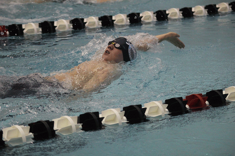 Doing the backstroke, senior Will Dervin competes in his race. 