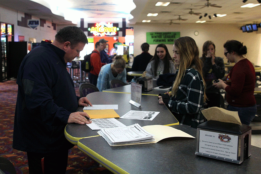 At the start of the Bowl-A-Thon on Tuesday, Jan. 26, sophomore Emily Jackson turns in her pledges.