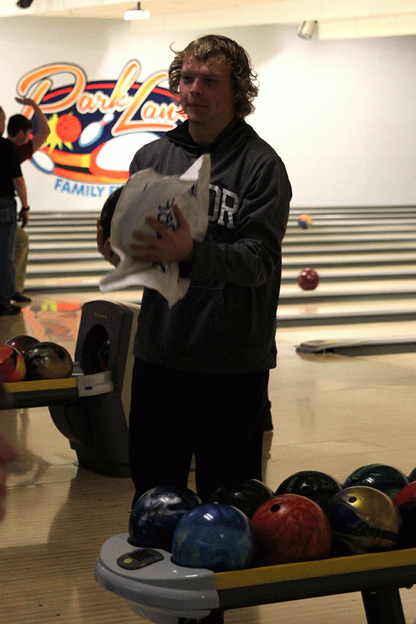 In preparation to bowl, senior Kole Johnston wipes off his bowling ball.