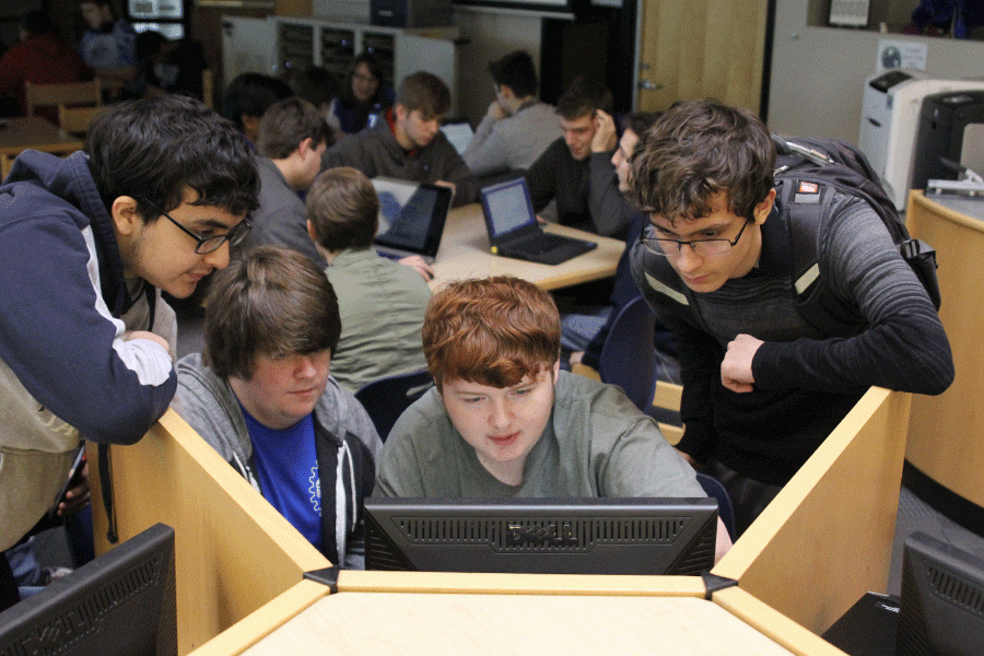 Sophomores Andres Rico, Gage Weber, Harrison Tucker and Zoltan Gothard work together to read the rules and strategize.