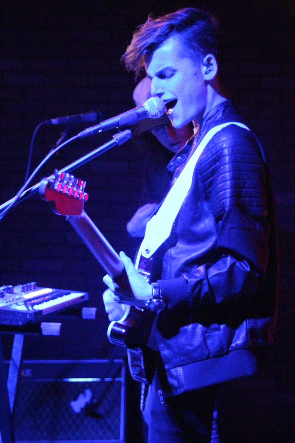 Ingram plays guitar as he sings.