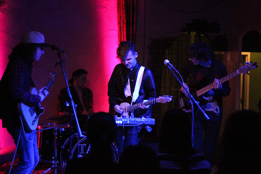 As he looks downward, Tall Tales lead vocalist/multi-instrumentalist Jack Ingram plays a guitar chord alongside guitarist-vocalist Rylan Fisher, drummer-vocalist Andrew Hosler and O'Halloran at The Art Factory in Overland Park on Saturday, Jan. 2. Tall Tales' headlining set included newly recorded music, music off the extended play "It's Just a Game" and covers.