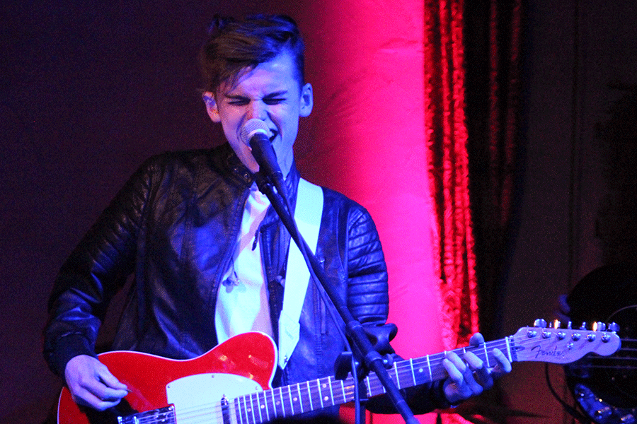 Ingram sings a note after strumming his electric guitar.